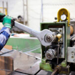 Worker adjusting machinery with large wrench